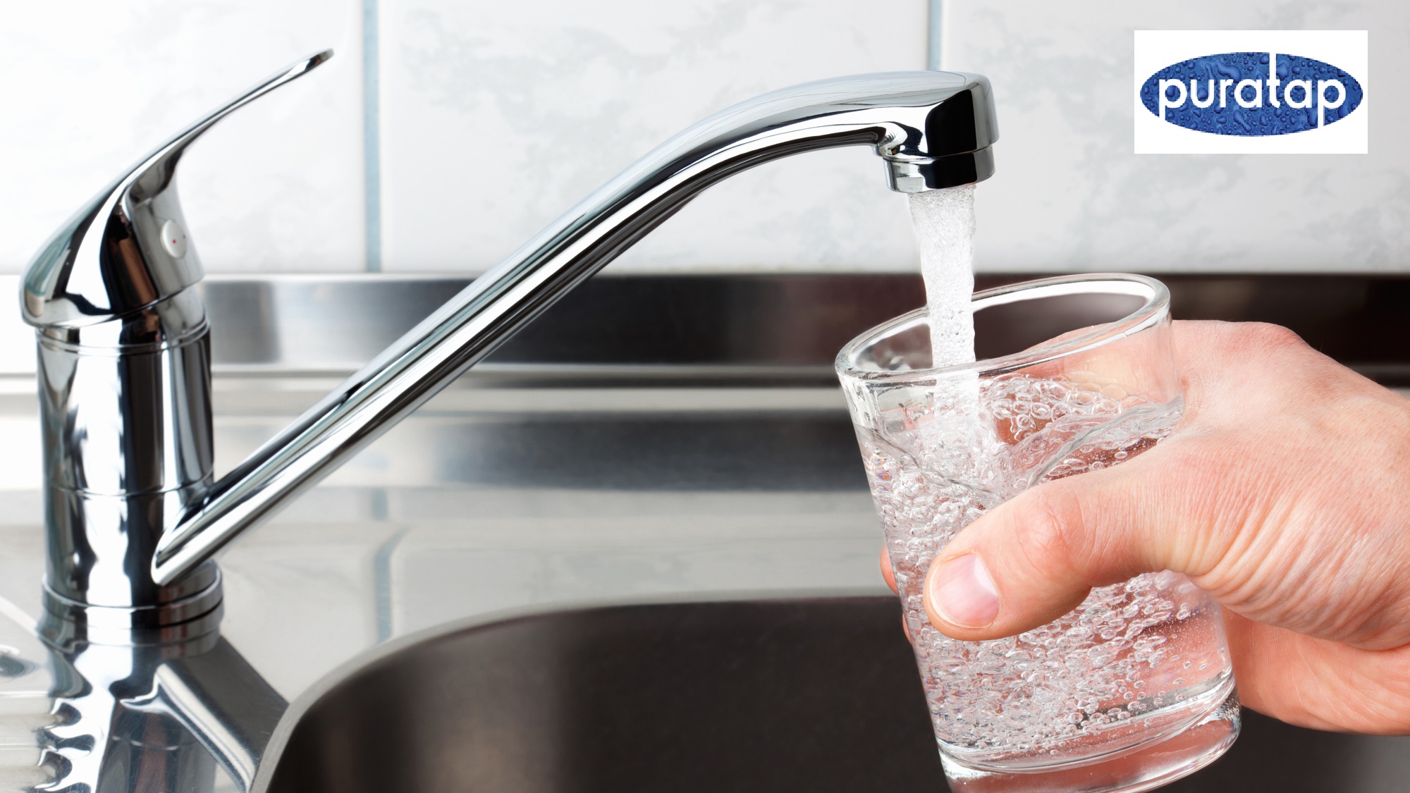 Glass filled with drinking water from kitchen faucet